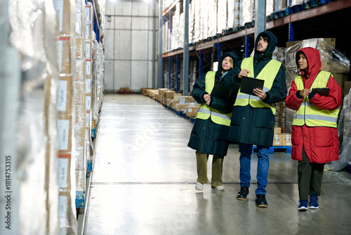 Cold chain workers checking inventory in large warehouse