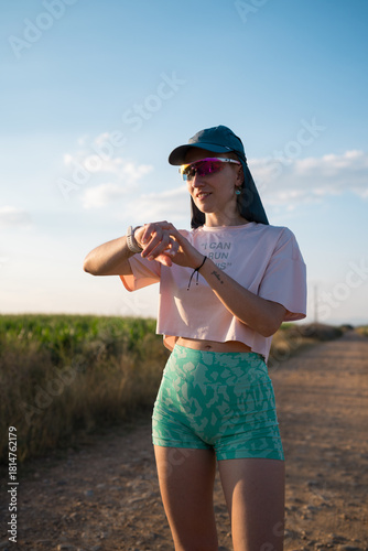 Young woman runner checking activity tracker during outdoor training