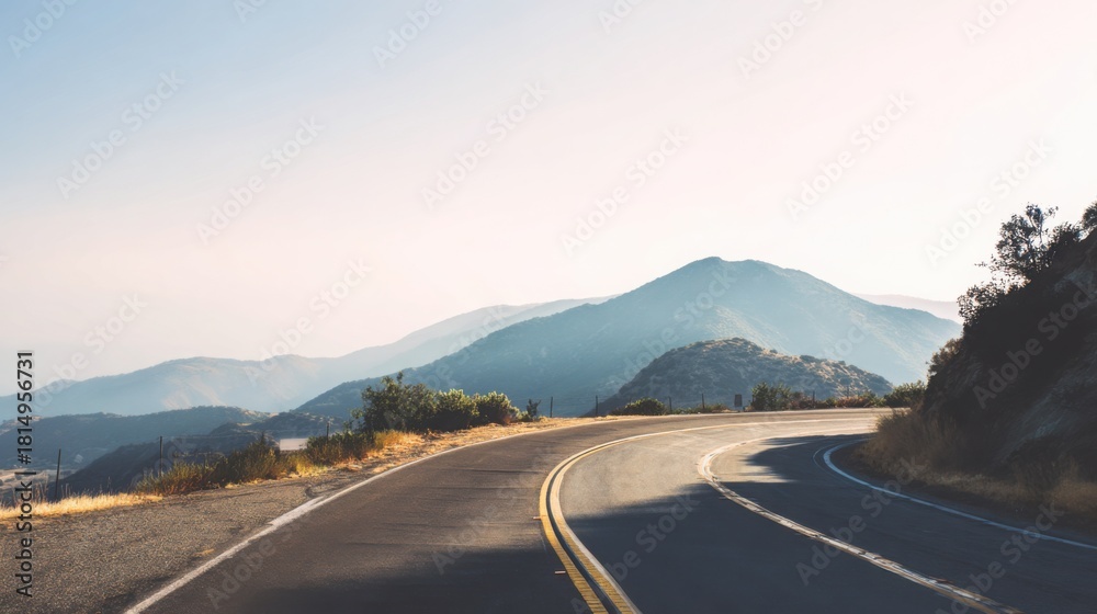 Fototapeta premium winding mountain road under clear sky, soft light, atmospheric haze, minimalistic travel vibe, serene and open landscape, peaceful and inspiring