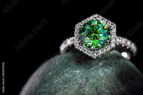 A green diamond ring sits on a rock