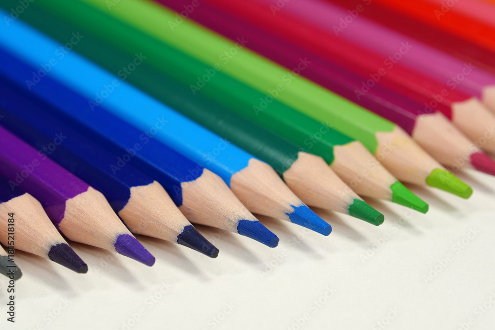 Fototapeta premium New wooden colored pencils of rainbow colors, perfectly sharpened, lie on table