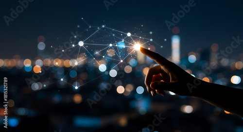 A person touches a glowing network structure over a blurred cityscape at night, symbolizing technology, connection, and innovation