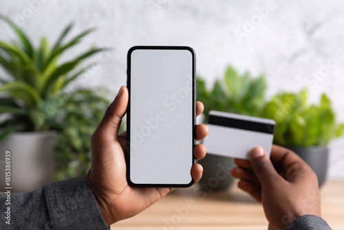 Mobile Payment: Capturing the essence of modern commerce, this image showcases a hand holding a mobile device and a credit card, symbolizing the ease and convenience of online transactions.