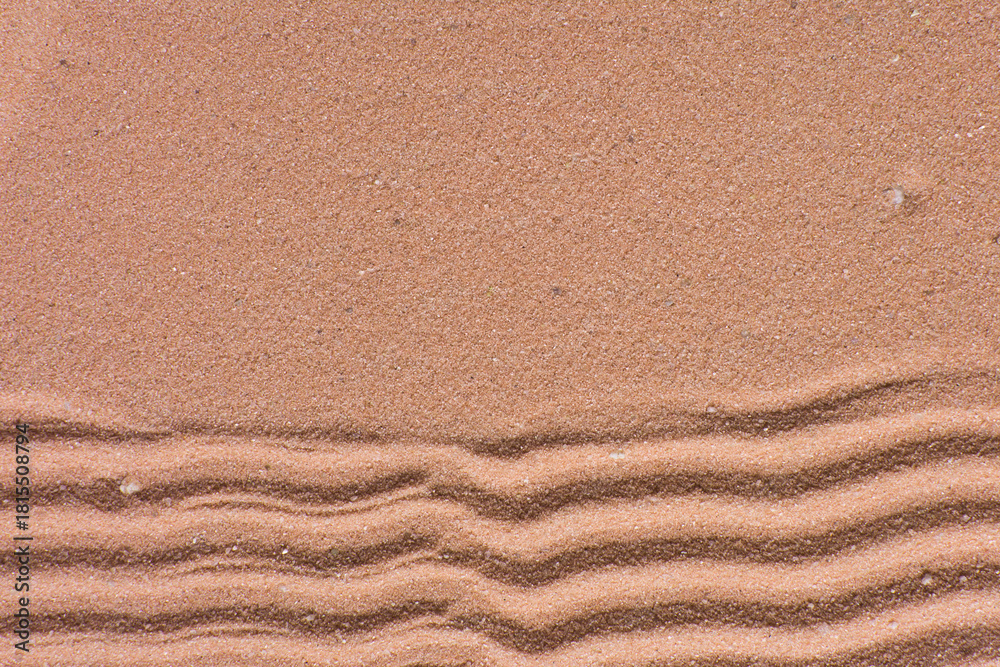 Obraz premium close up view of textured brown sand background, beautiful sand texture, overhead view of zen pattern drawn in brown sand, Top view of fine grain texture