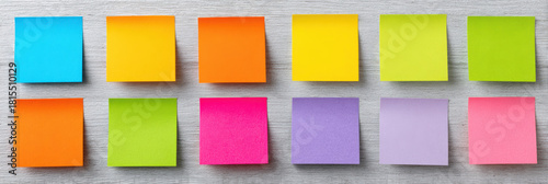 Vibrant collection of colorful blank sticky note paper on an office wall. This organized memo and reminder background feels full of creative potential for any project