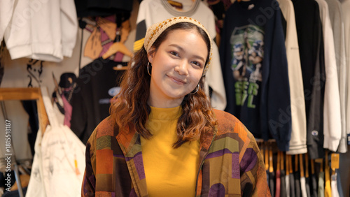 Young teen Gen Z asia female happy smile looking at camera at zero waste eco go green buy second hand sale store flea market mall thrift old used vintage fabric retro style. Woman people enjoy shop.
