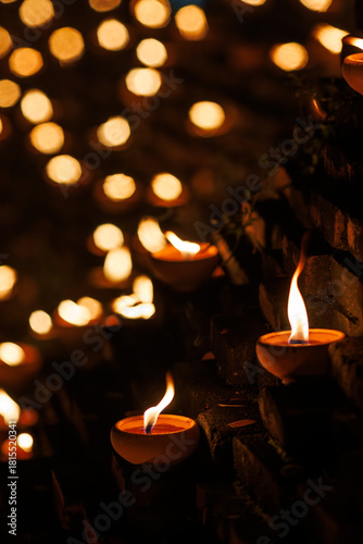 clay oil lamps lit along the brick walls at Jaeng Hua Rin and around the Chiang mai moat, their warm flames glowing softly at night during the Yi Peng festival