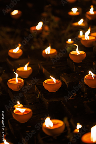 clay oil lamps lit along the brick walls at Jaeng Hua Rin and around the Chiang mai moat, their warm flames glowing softly at night during the Yi Peng festival