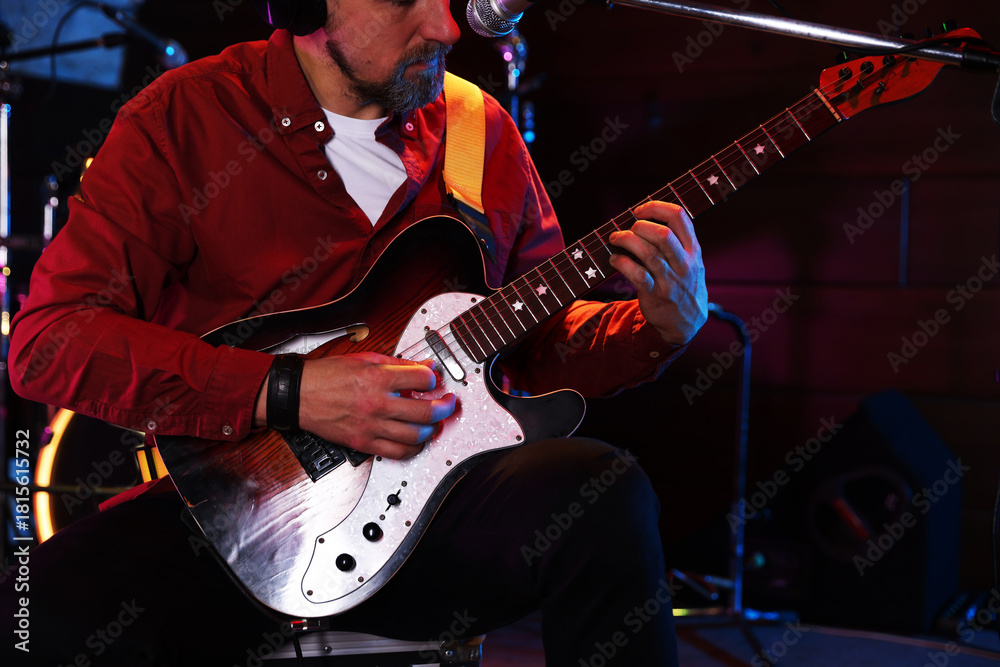Obraz premium Man playing electric guitar on stage, closeup