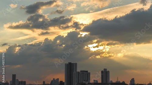Time-lapse of Warm beams breaking through the clouds, illuminating the city with a divine glow.