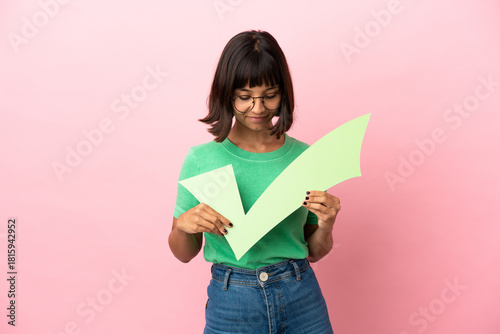 Youing woman holding a check icon and looking it
