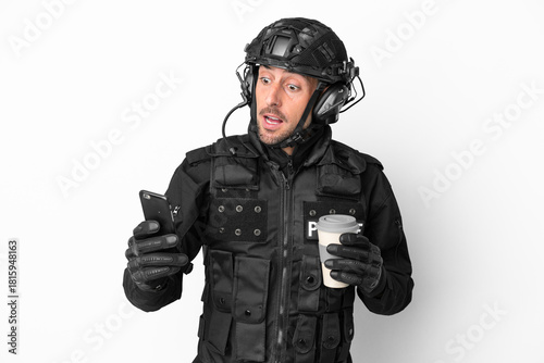 SWAT caucasian man isolated on white background holding coffee to take away and a mobile