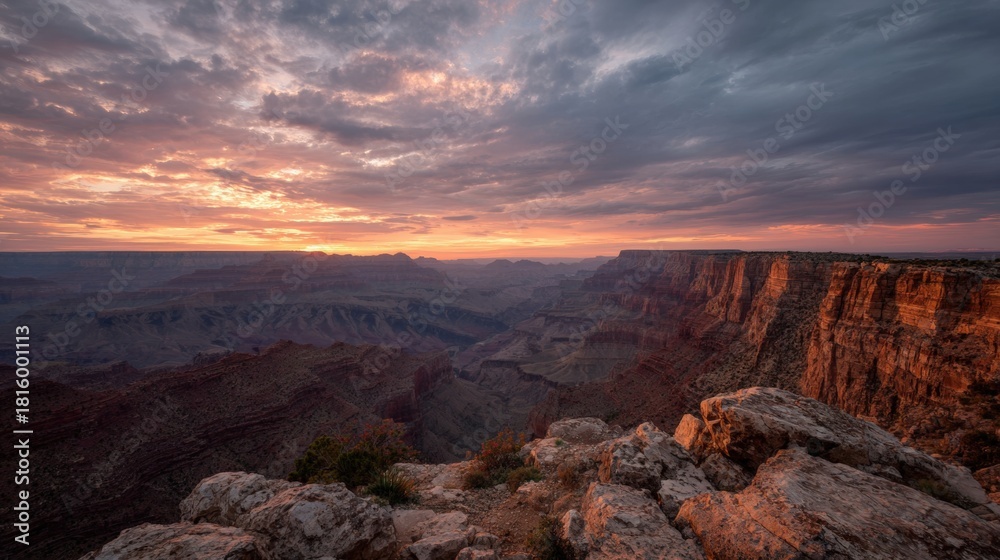 Obraz premium Landscape photograph of the grand canyon at sunset. the sky is filled with orange and pink hues, with the sun setting in the distance.
