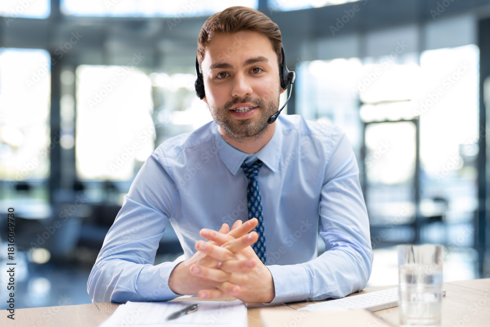 Fototapeta premium Smiling friendly handsome young male call centre operator.