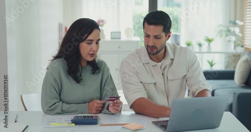 Young Latin couple male, female customers paying by credit card online and laptop shopping online furniture decorate home in living room at home. Young married moving home shopper online concept.