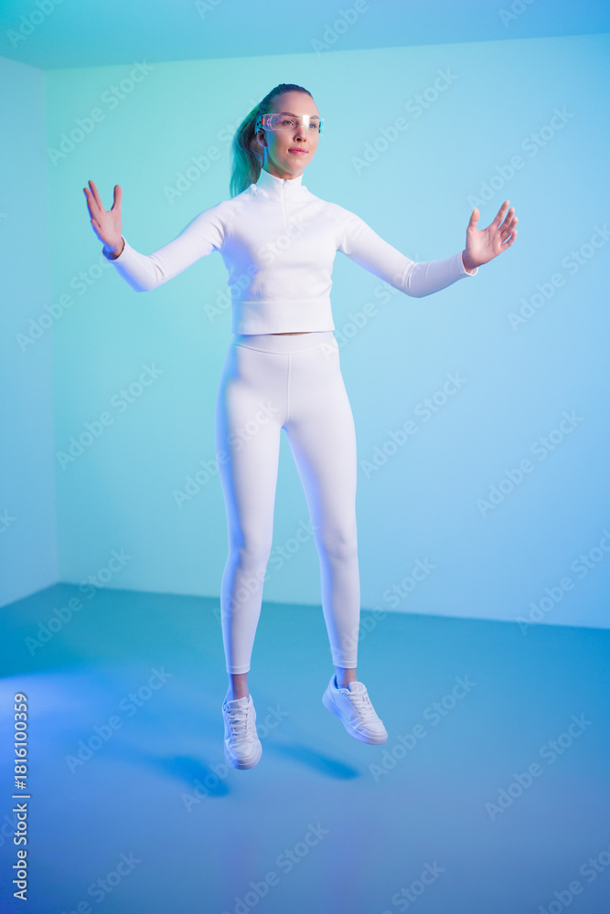 Obraz premium Female in smartglasses jumping against blue background