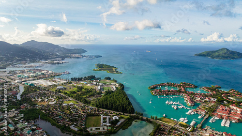 Urban landscape with houses and buildings, leading to a coastal area with wind turbines. Victoria city. Seychelles, Mahe.