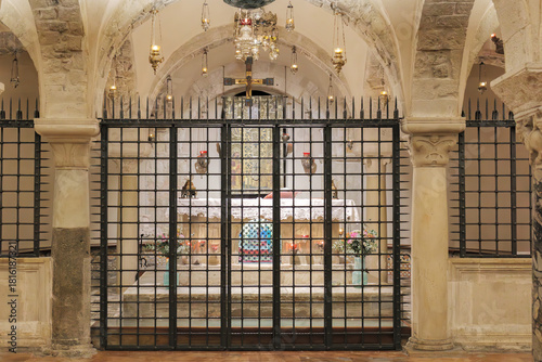 Bari, Italy. Chapel in the crypt of the Basilica of San Nicola in Bari, where the relics of Saint Nicholas are kept, framed by stone arches, hanging lamps and an iron gate. 2025-04-15.