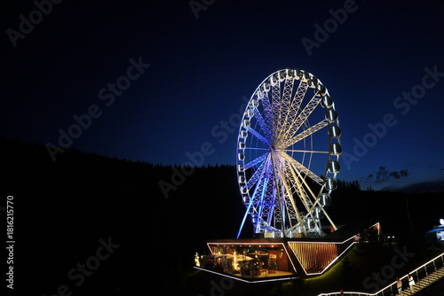 Ferris wheel with lights at night in the Carpathians Ukraine