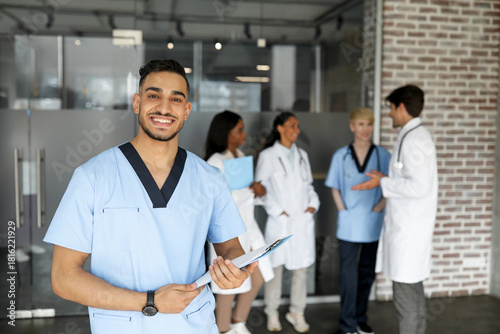 Fényképezés Cheerful middle-eastern young man in workwear doctor attending medical conferenc