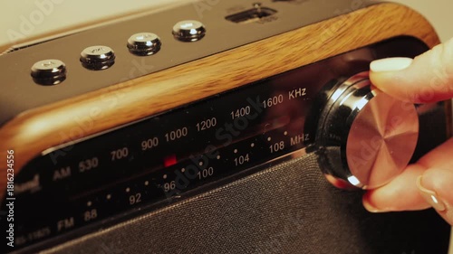 Tuning an analog radio station frequency. Hand turns the tuning knob, adjusting indicator while scanning various radio frequencies. High quality 4k footage