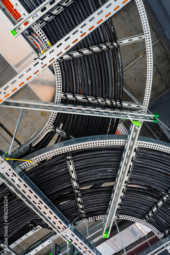 Close-up of industrial electrical installations and cable trays. Intricate network of power cables and wires for industrial or commercial infrastructure.