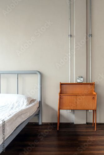 Interior of a hotel room with bed and wooden bedside table