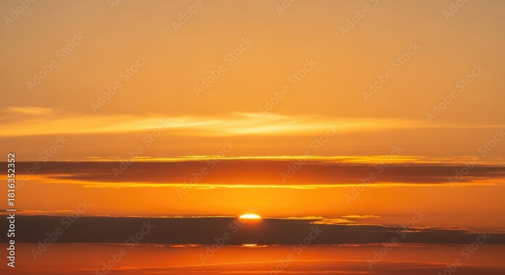 Obraz premium Vibrant Golden Sunset Sky with Dramatic Fiery Clouds and Warm Light