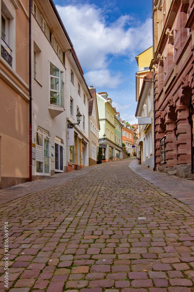 Fototapeta premium A peaceful uphill cobblestone street lined with colorful historic buildings in Baden-Baden, Germany