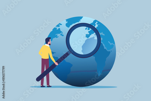 Man with magnifying glass examining the world globe for business opportunities