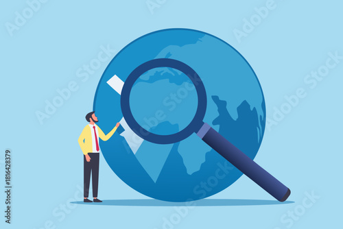 Businessman examining world globe with magnifying glass global business analysis