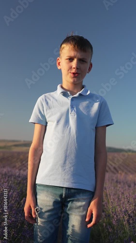 Boy field portrait young boy stands in sunny lavender field looking serious then smiling Vertical video