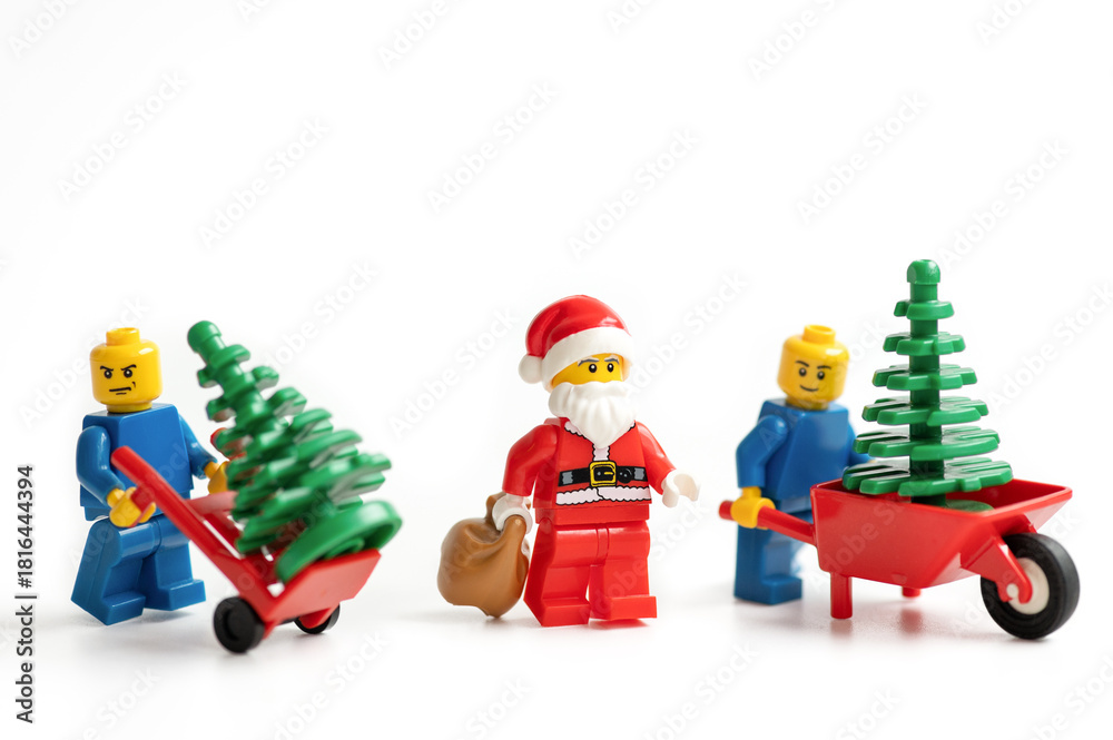 Naklejka premium Miniature figurines with Christmas trees and Santa Claus on a white background.