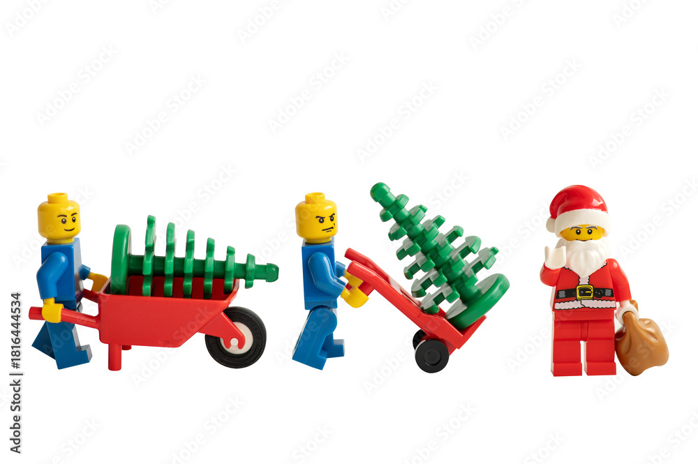 Obraz premium Santa Claus and miniature figurines with a wheelbarrow and Christmas tree on a white background