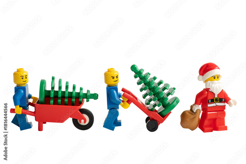 Naklejka premium Santa Claus and miniature figurines with a wheelbarrow and Christmas trees on a white background