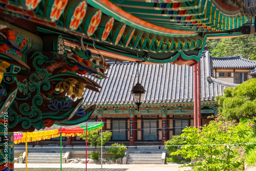 colorful wooden eaves and a hanging electric lamp at the Buddhist temple building