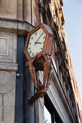 Reloj con esculturas en un edificio.