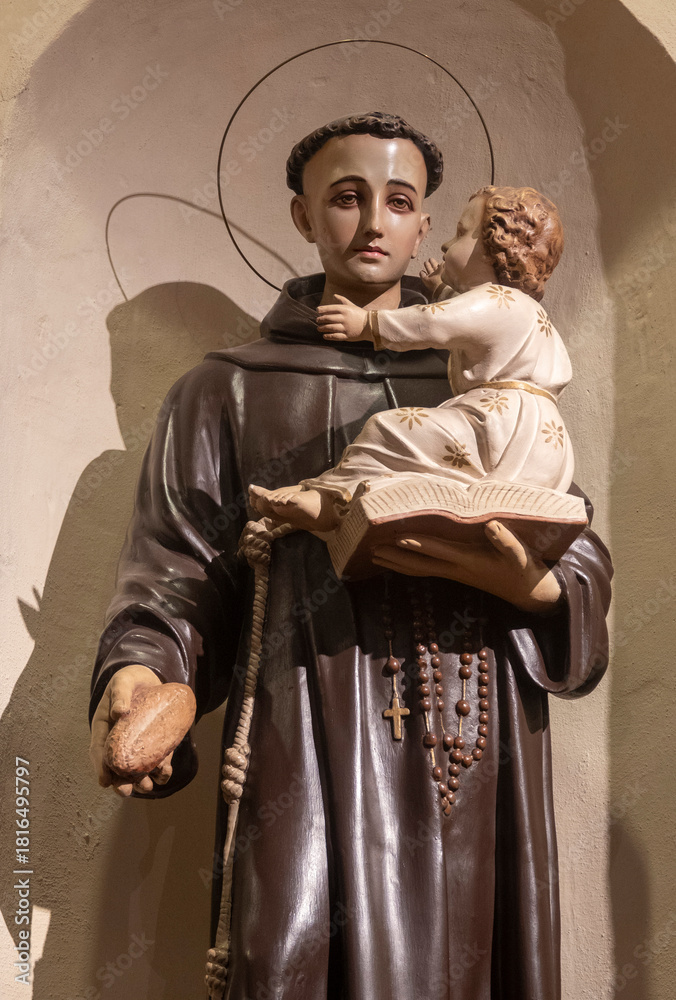 Naklejka premium Statue (19th century) of Saint Anthony of Padua holding baby Jesus Christ in his arms.