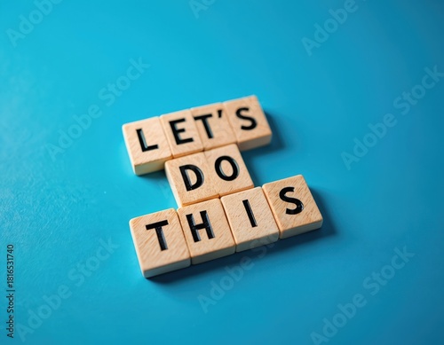 Wooden blocks spell Lets on blue background. Phrase inspires immediate action, positive mindset, new beginnings. Represents challenge, goal setting, future success. Concept for business, personal