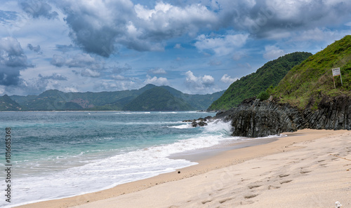 Lombok Indonesia – Waves crashing against rocks at Mawi Beach with sweeping views of the Lombok coastline.