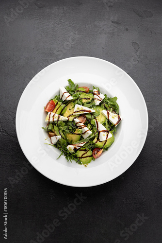 Fresh avocado and feta salad with arugula, cherry tomatoes and balsamic drizzle