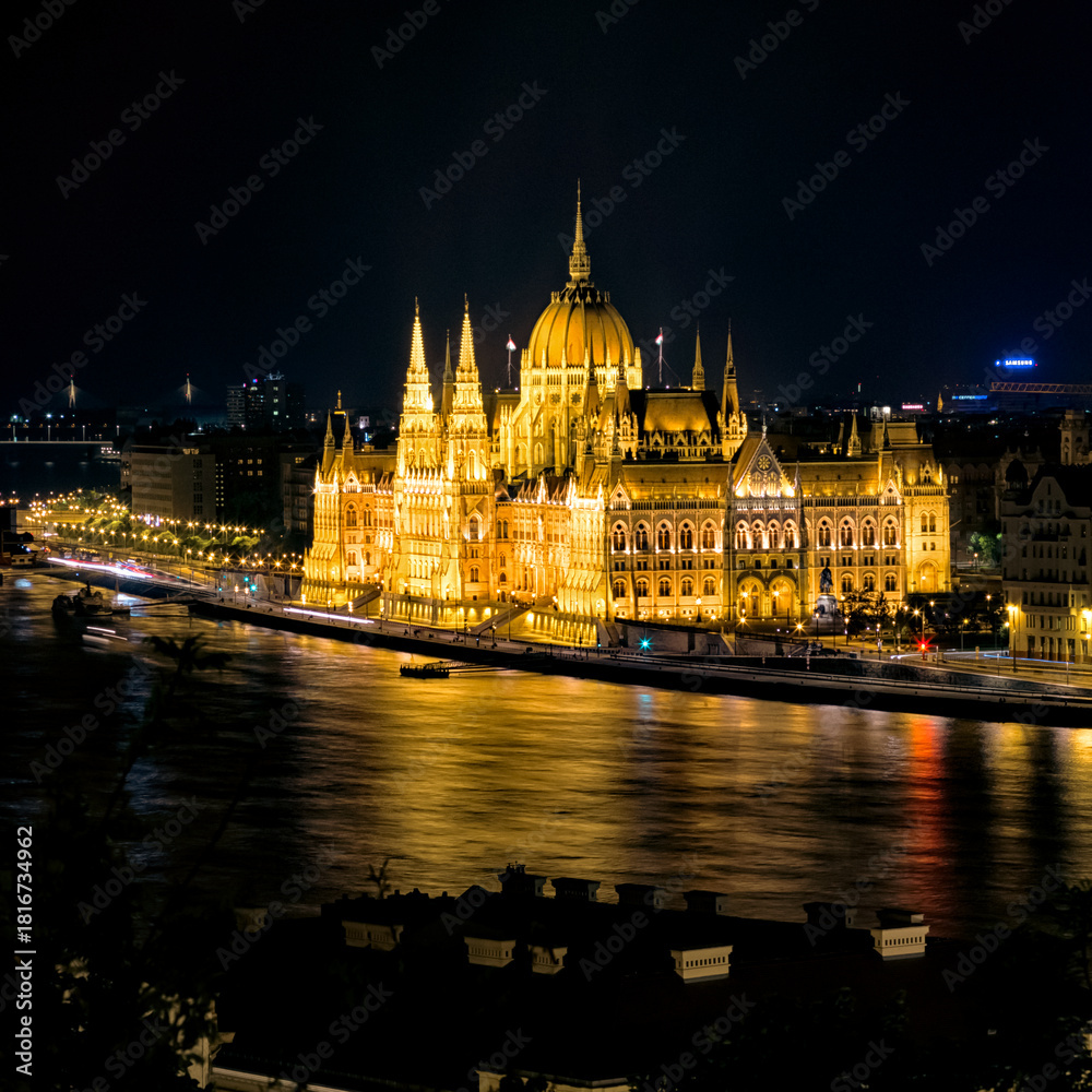 Obraz premium Illuminated Hungarian Parliament Building reflecting on the Danube River in Budapest at night