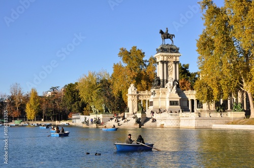Boats on the lake at El Retiro Park in Madrid, with the Monument to Alfonso XII surrounded by autumn trees.