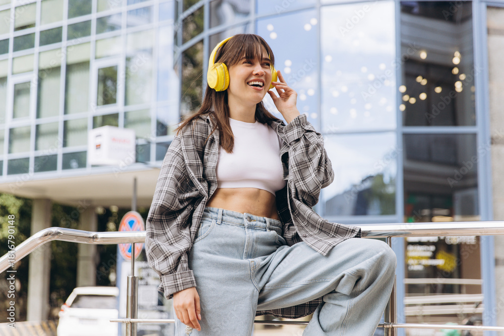 Fototapeta premium Young woman enjoying music listening with yellow headphones