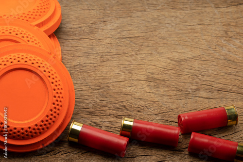 Clay disc flying targets and shotgun bullets on wooden background ,Clay Pigeon target