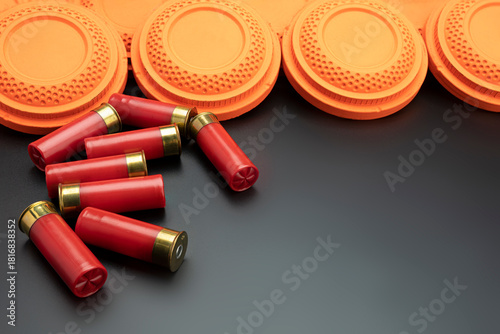 Clay disc flying targets and shotgun bullets on black background ,Clay Pigeon target