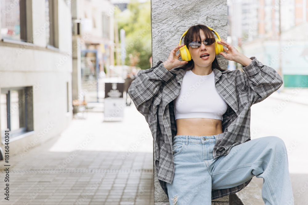 Fototapeta premium Young woman enjoying music on urban street