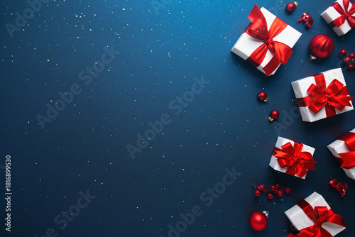 Merry Christmas and Happy Holidays greeting card, frame, banner. New Year. Noel. Red and white Christmas decorations and gifts on blue background top view. Winter xmas holiday celebration theme.