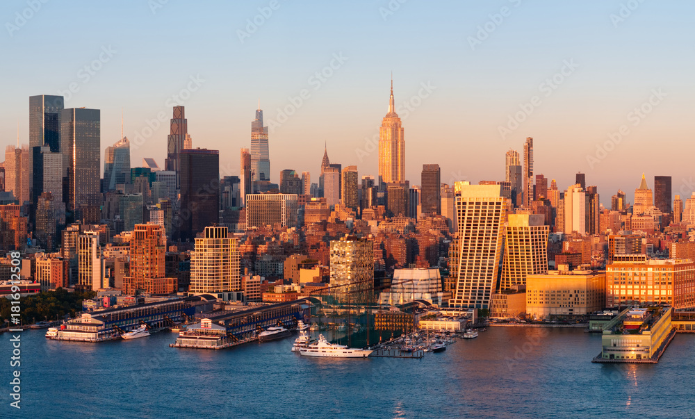 Fototapeta premium Aerial panoramic view of the Manhattan skyline at sunset, with Midtown skyscrapers, Hudson River waterfront and Chelsea piers. New York City, USA