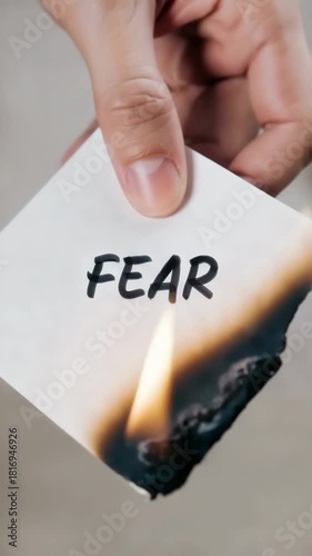 Burning paper with word fear written on it, concept of courage, emotional release, overcoming anxiety, inner strength and mental resilience symbolism